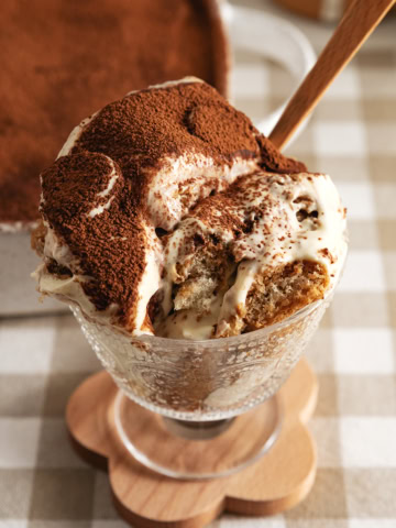 A glass serving cup filled with banana pudding tiramisu.