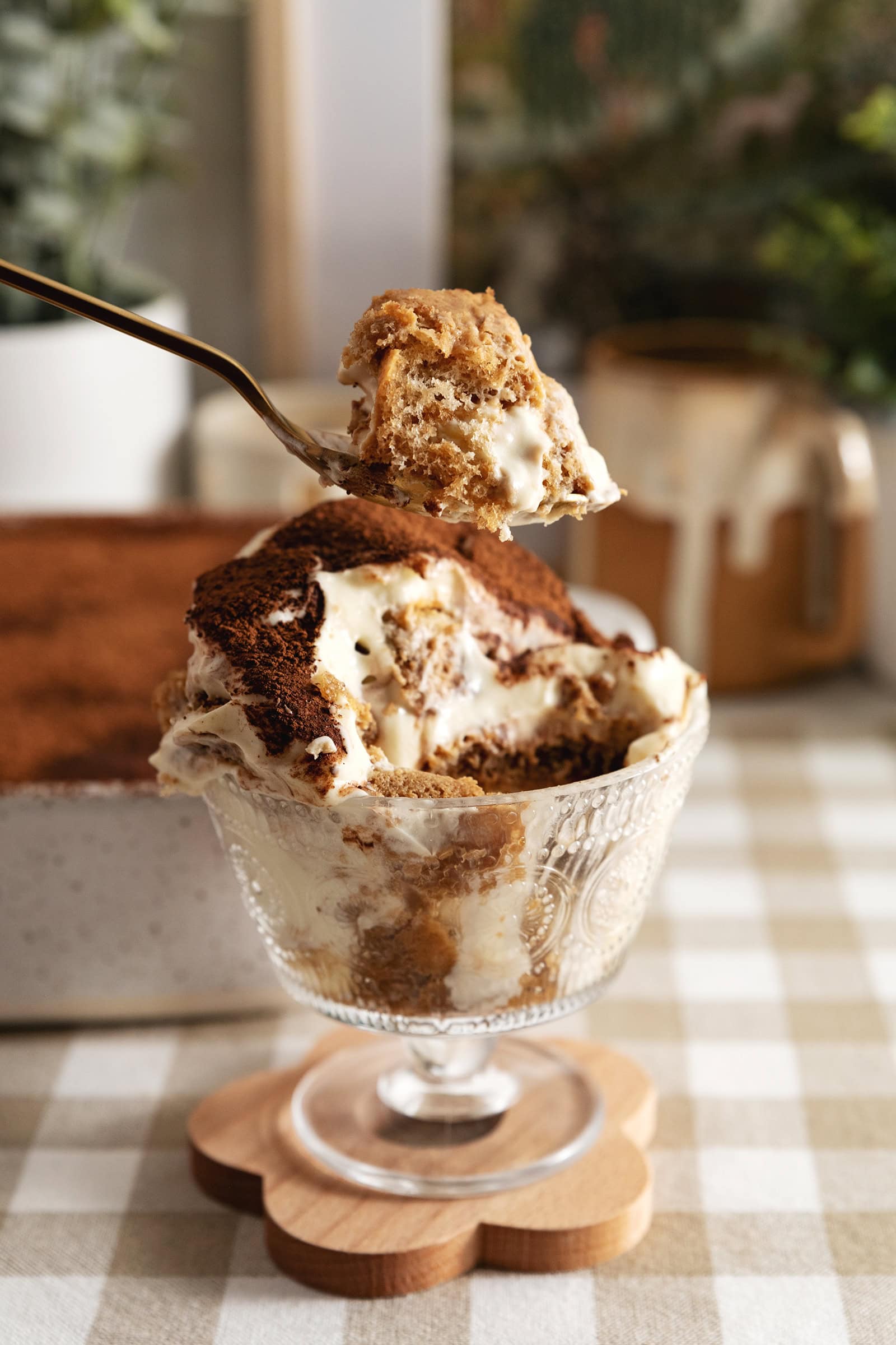 Lifting a spoonful of banana pudding tiramisu above the rest of the bowl.