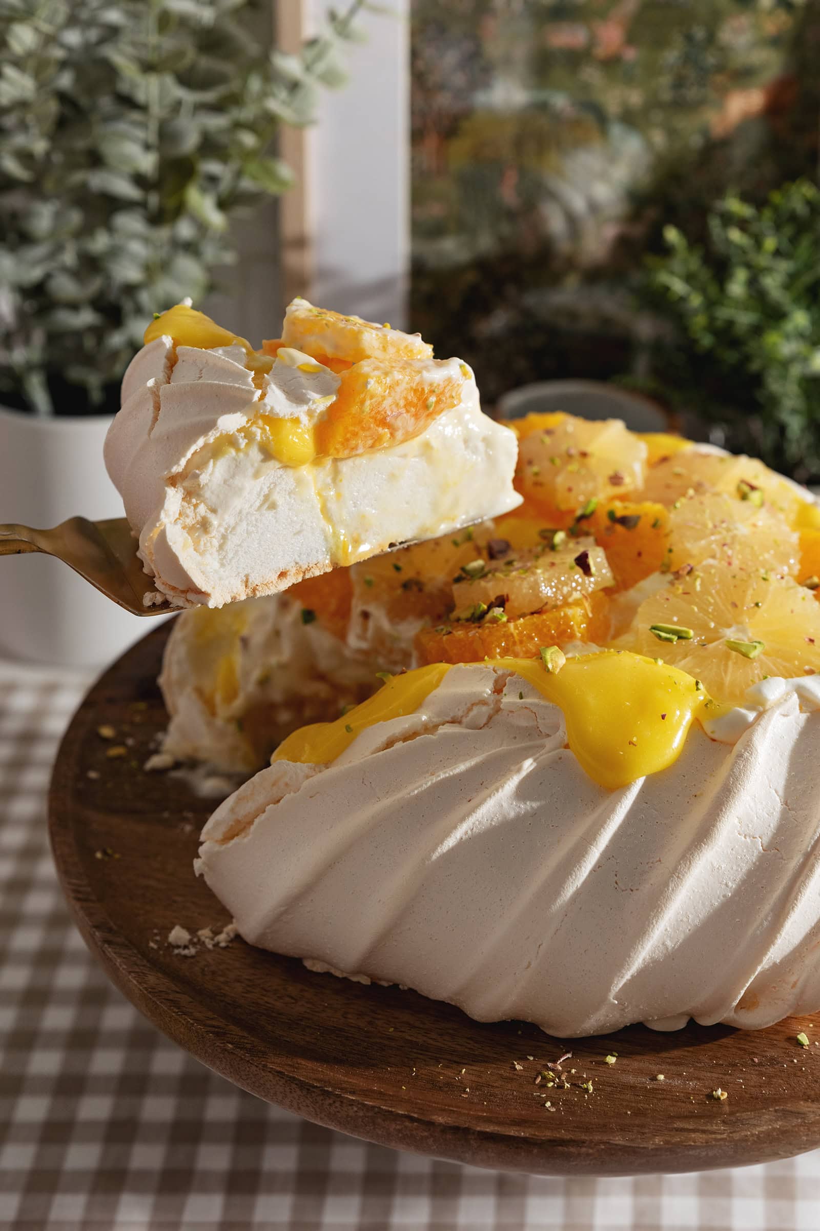 Lifting a slice of citrus pavlova above the rest of the pavlova.