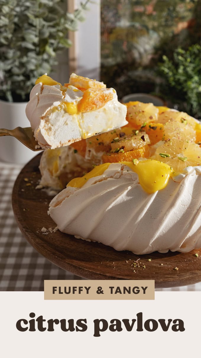Lifting a slice of citrus pavlova above the rest of the pavlova.