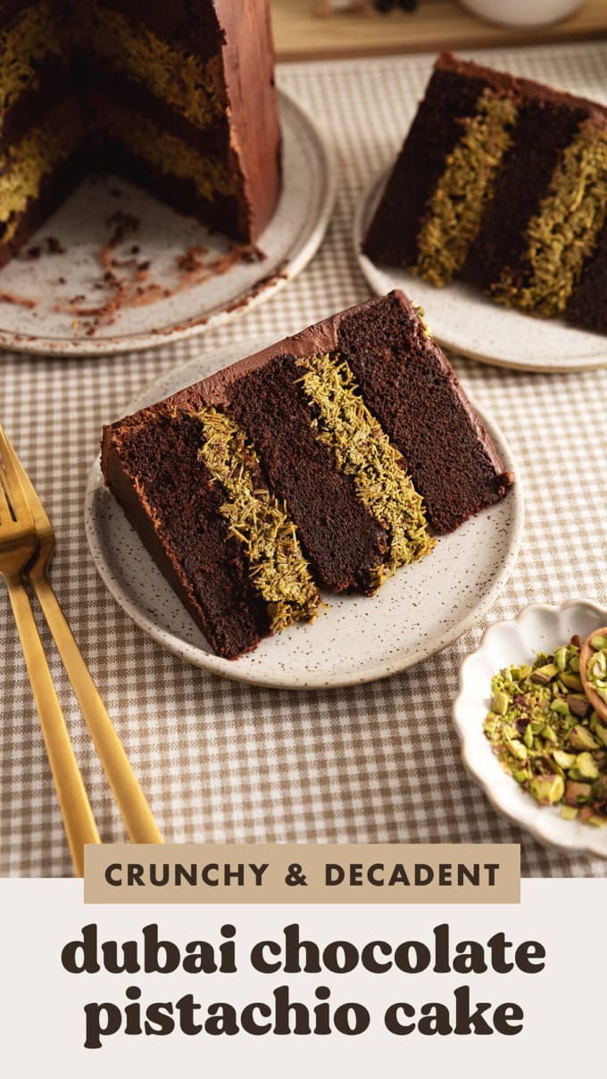 A slice of Dubai chocolate pistachio cake on a speckled plate showing the layers of chocolate cake and pistachio kataifi inside.