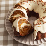 Two slices of carrot bundt cake leaning against each other next to the rest of the cake.