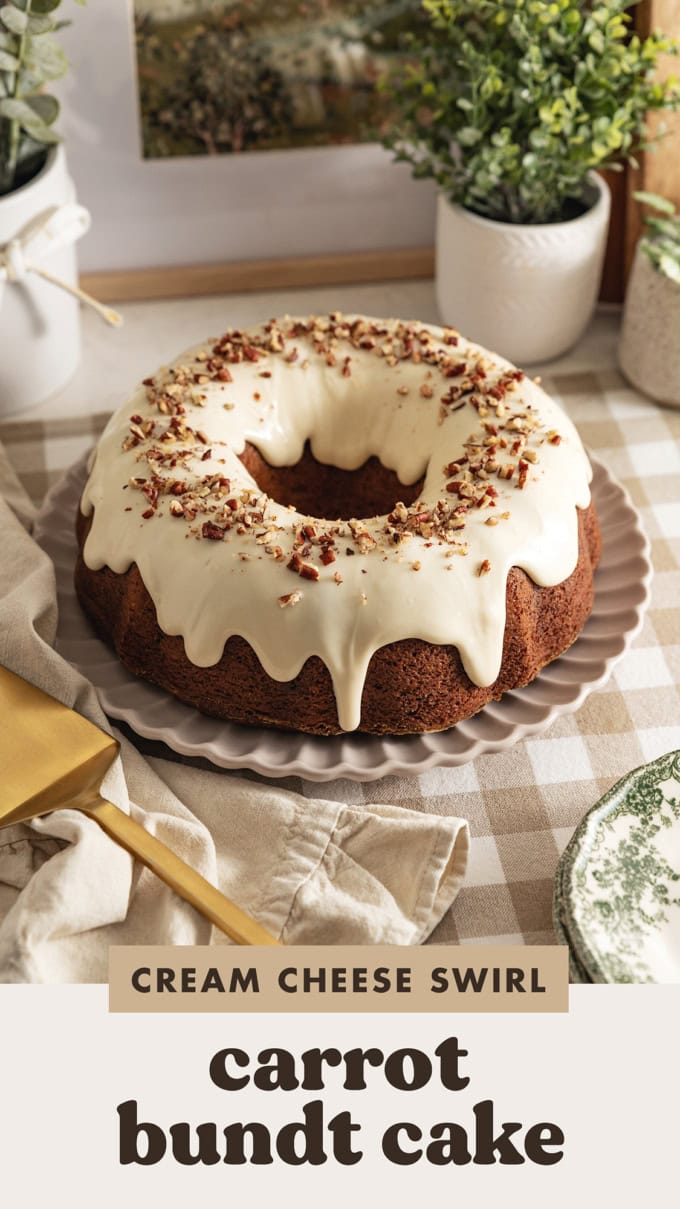 A carrot bundt cake with cream cheese frosting dripping down the sides on a kitchen counter.