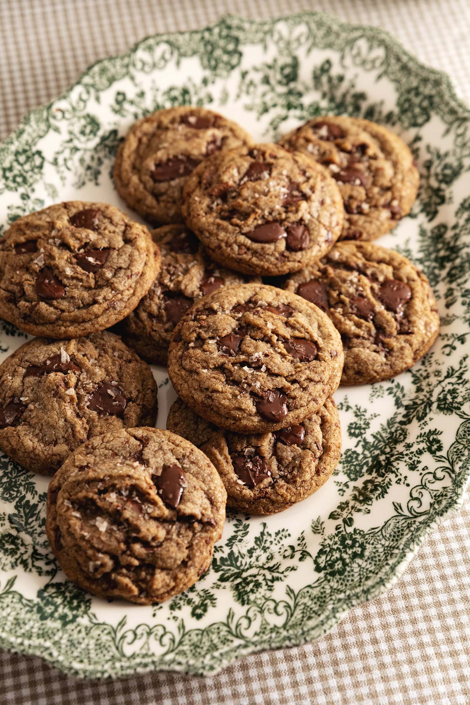 A pile of espresso chocolate chip cookies on a vintage serving platter.