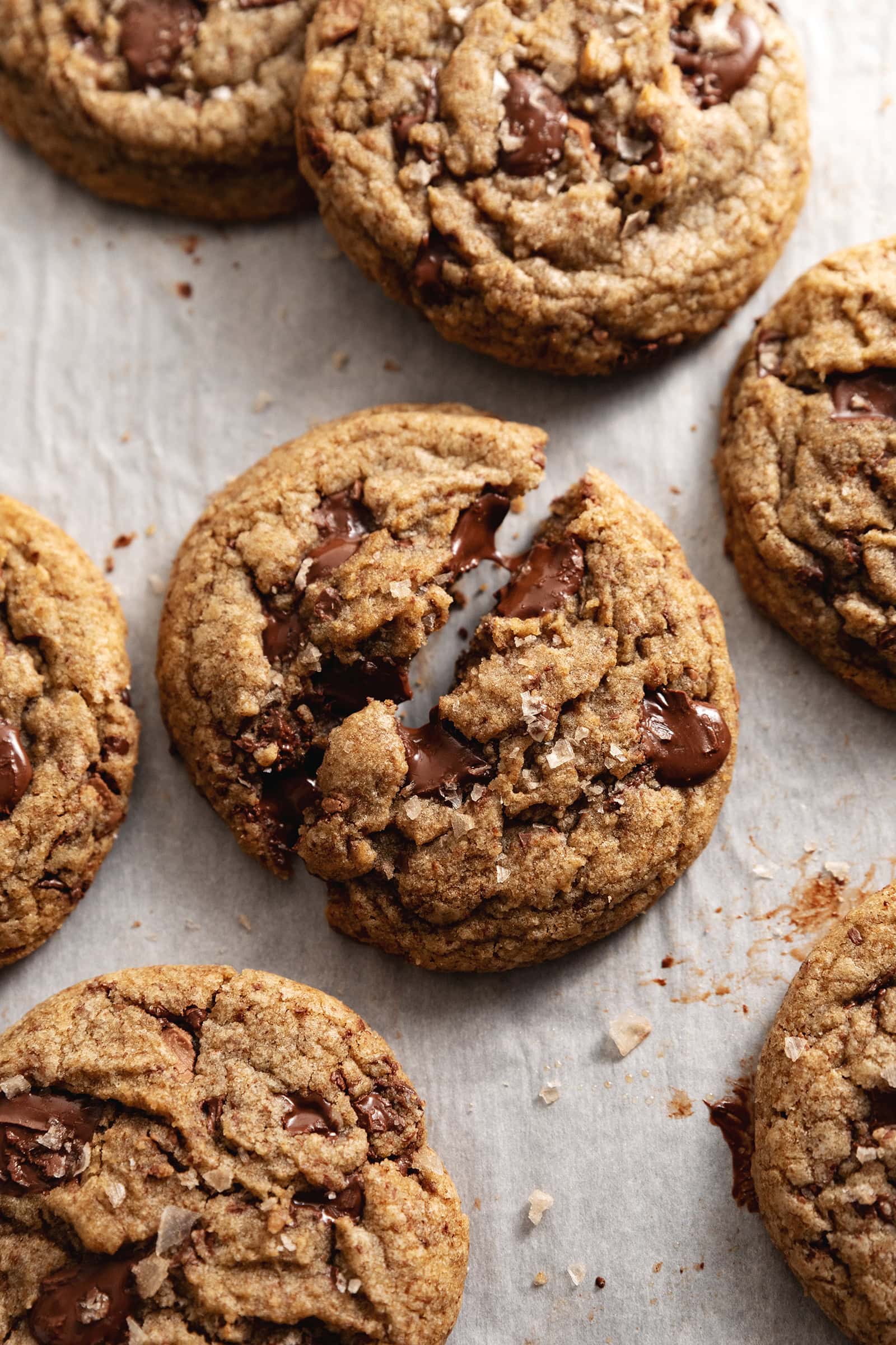 An espresso chocolate chip cookie split in half and slightly pulled apart to show the gooey melted chocolate.