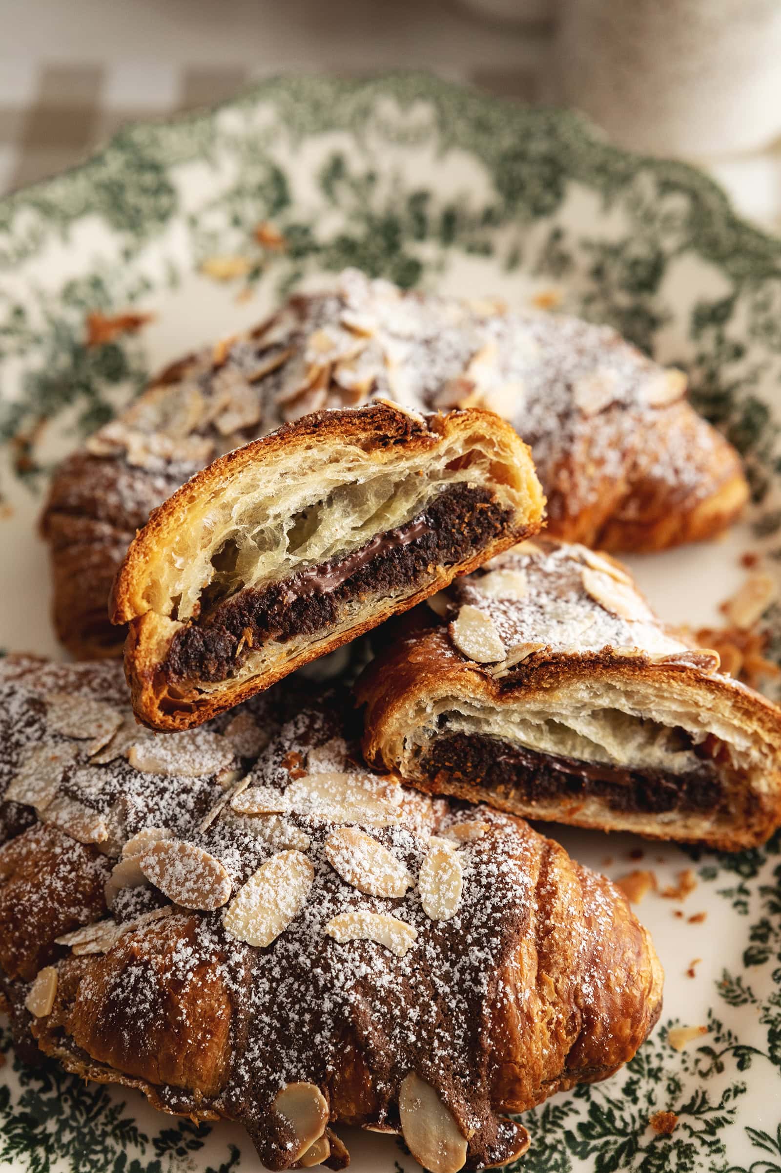 A chocolate almond croissant cut in half to show the chocolate frangipane inside.