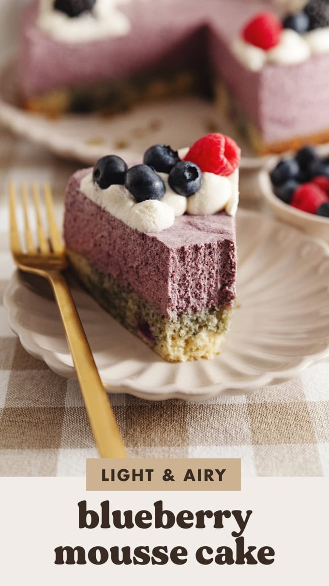 A slice of blueberry mousse cake with a forkful taken out of it to show the airy mousse texture.