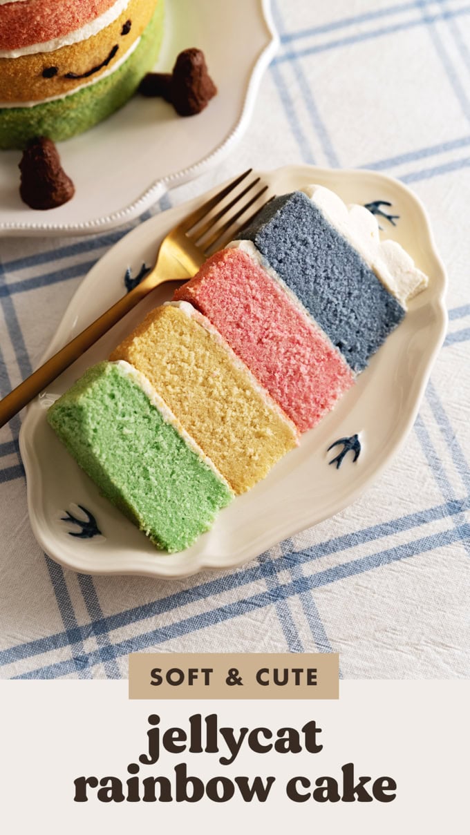 A slice of Jellycat rainbow cake on a plate with a fork.
