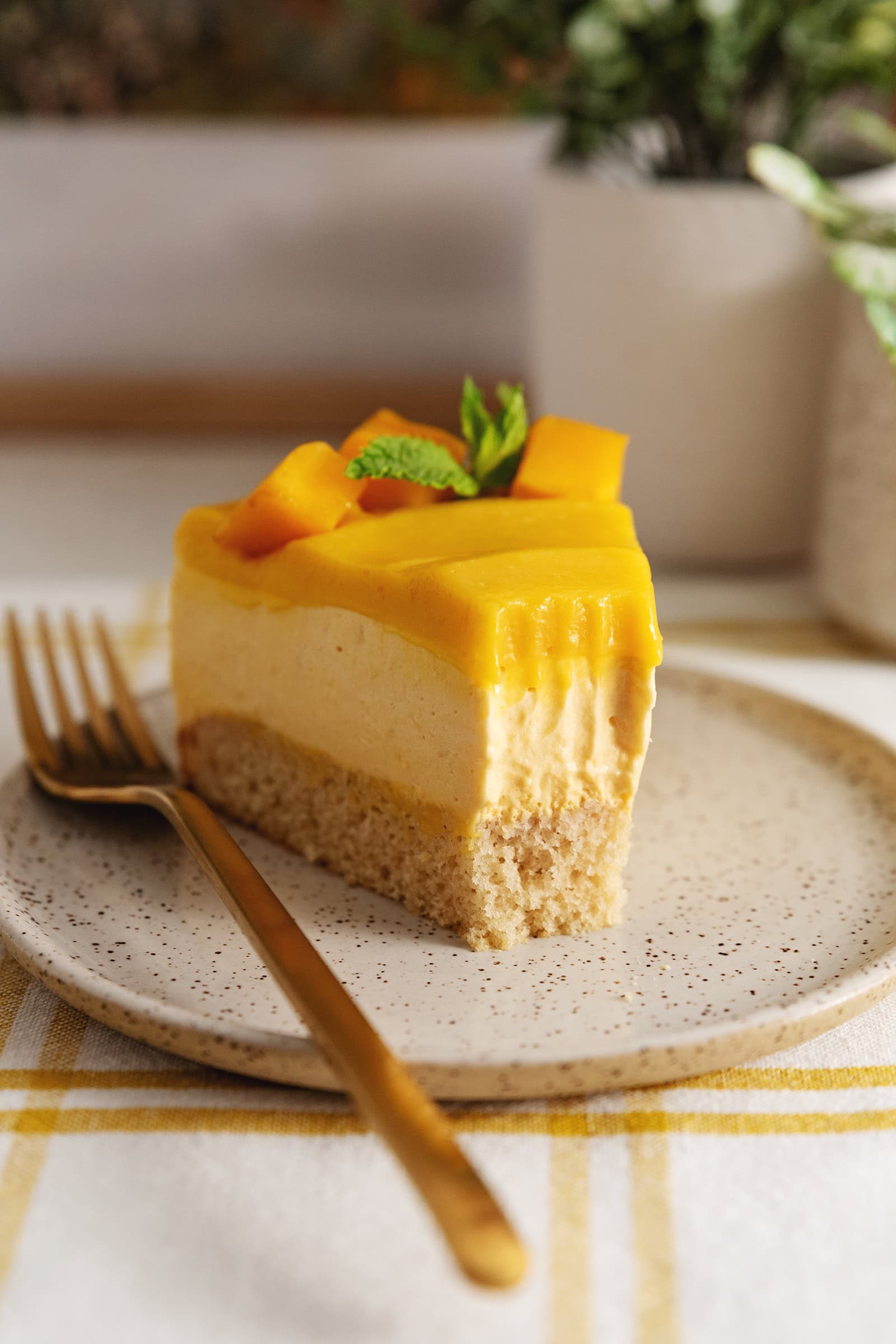 Close-up of a slice of mango mousse cake with a forkful taken out of it.