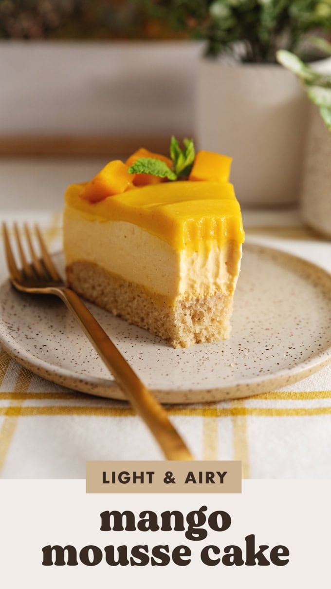 Close-up of a slice of mango mousse cake with a forkful taken out of it.