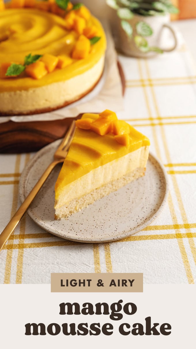 A slice of mango mousse cake on a plate in front of the rest of the cake.