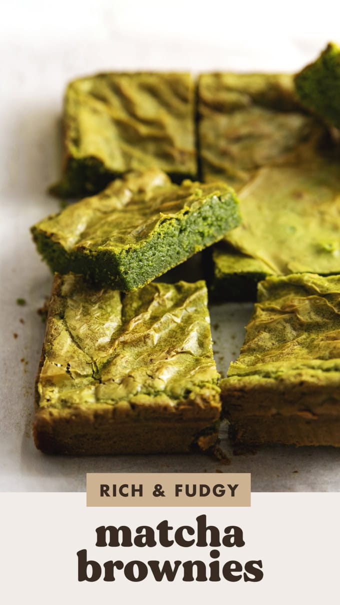 Close-up of a matcha brownie rest on other brownies on parchment paper.