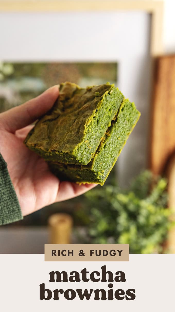 Hand holding two matcha brownies in a stack to show the texture.