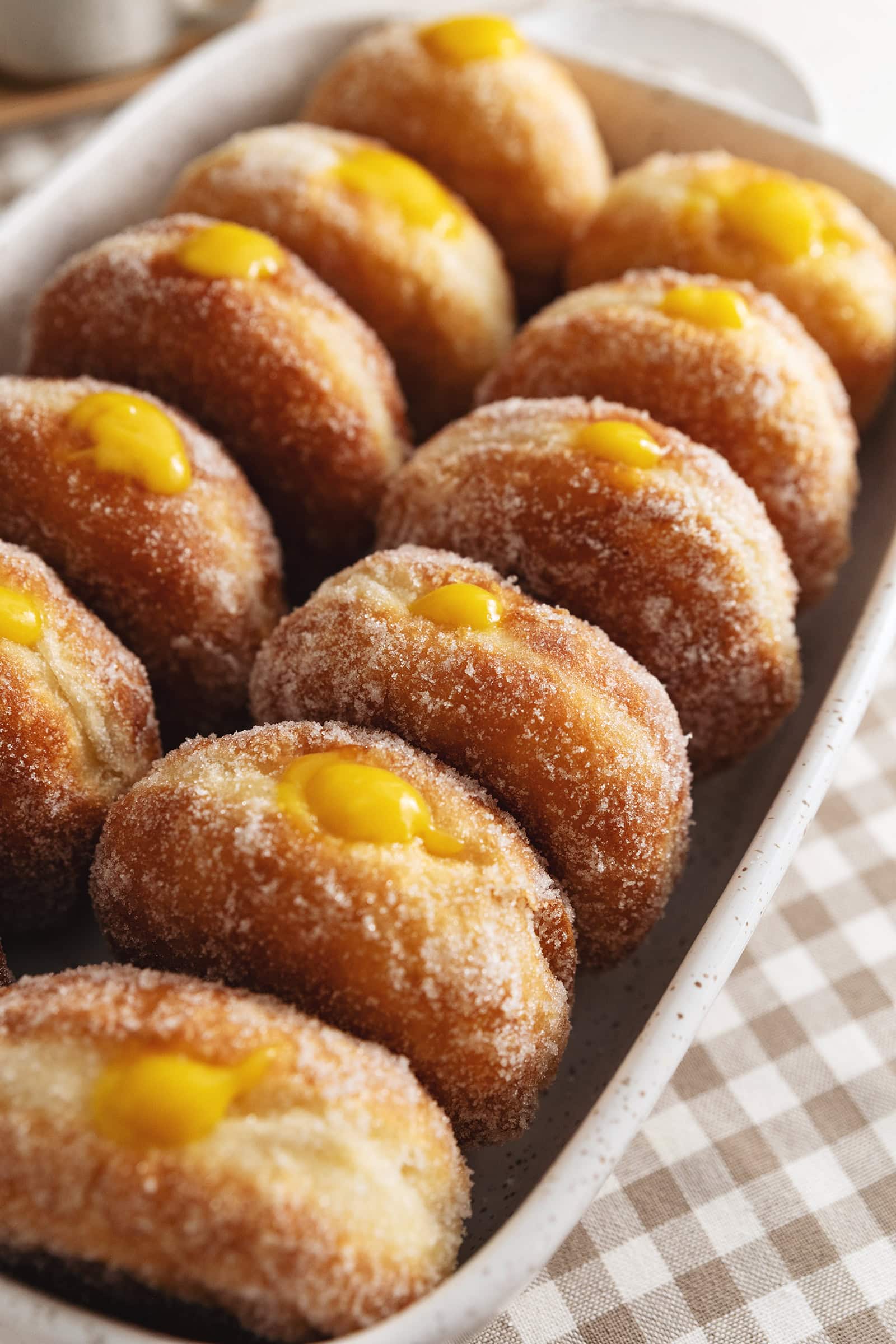 Several mango brioche donuts lined up in a baking dish.