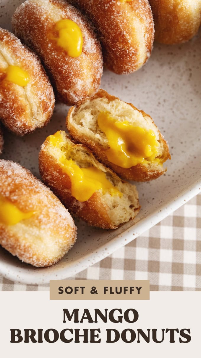 A mango brioche donut split in half to show the mango curd filling inside.