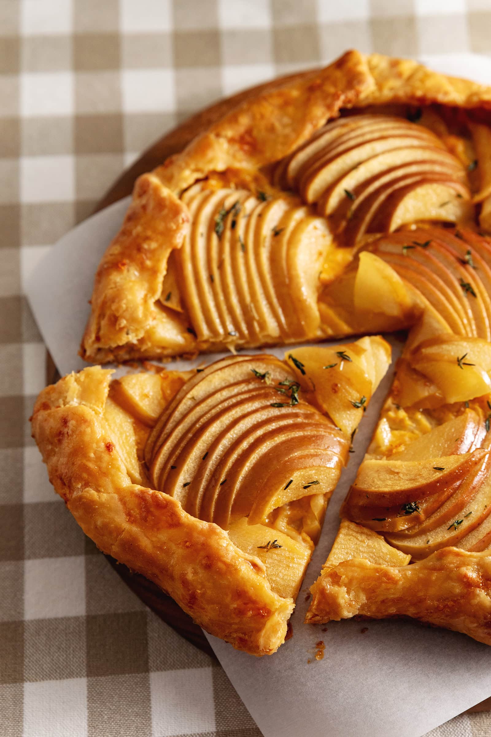 A triangular slice of an apple cheddar galette cut from the rest of the galette.