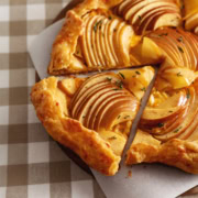 A triangular slice of an apple cheddar galette cut from the rest of the galette.