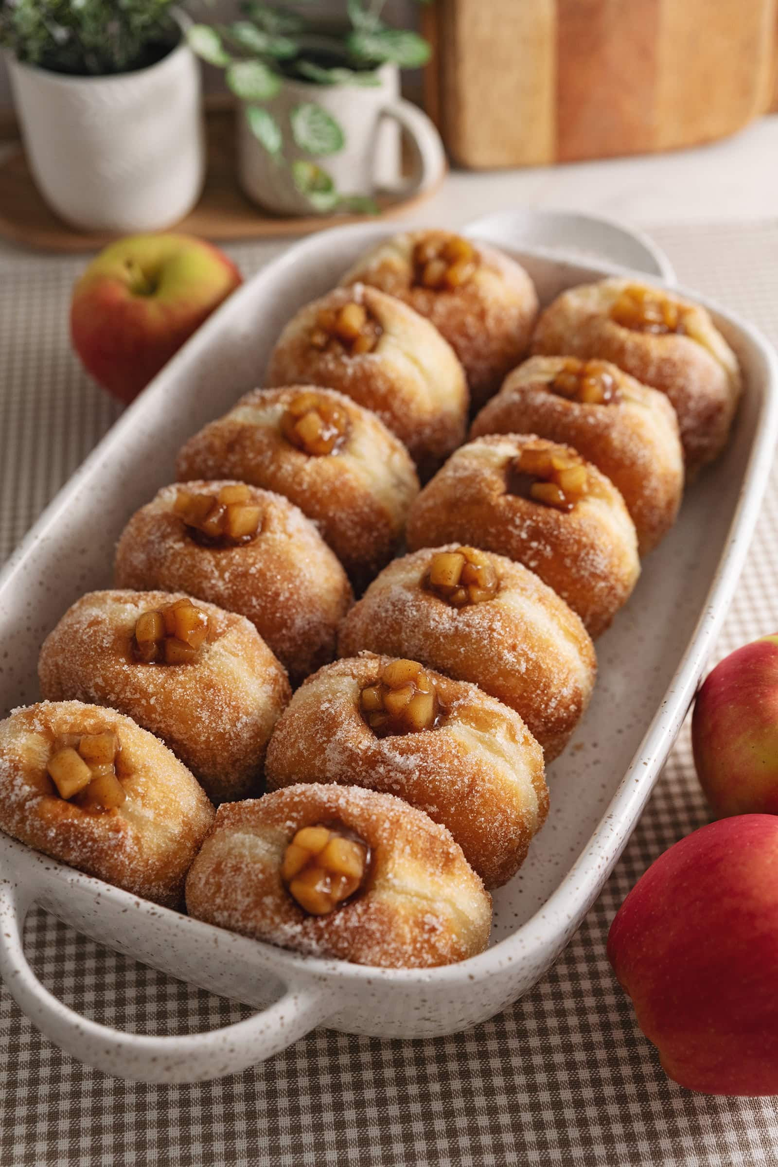 Two rows of apple pie donuts lined up in a baking dish.