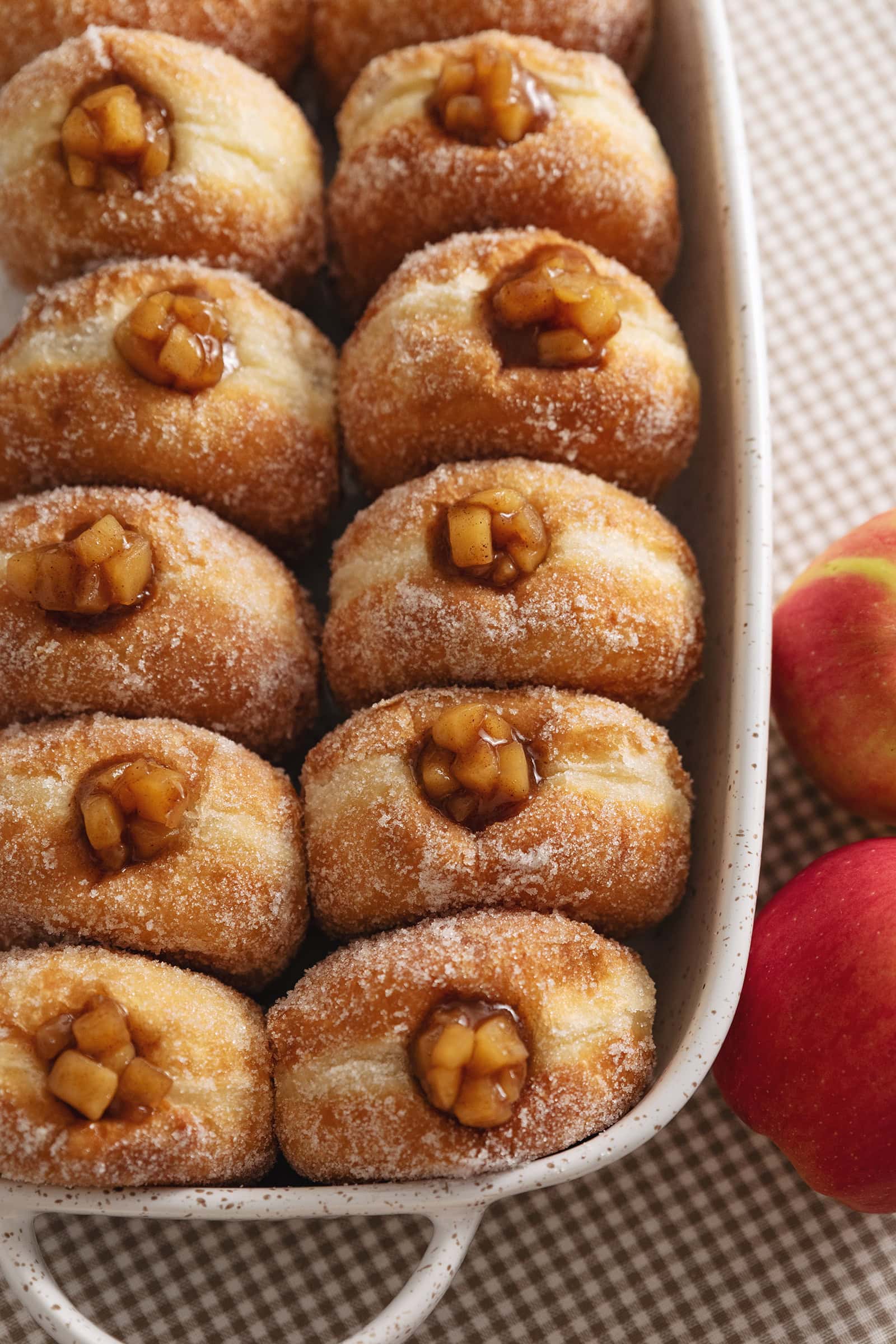 Two rows of apple pie donuts lined up in a baking dish.