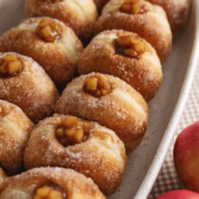 Two rows of apple pie donuts lined up in a baking dish.
