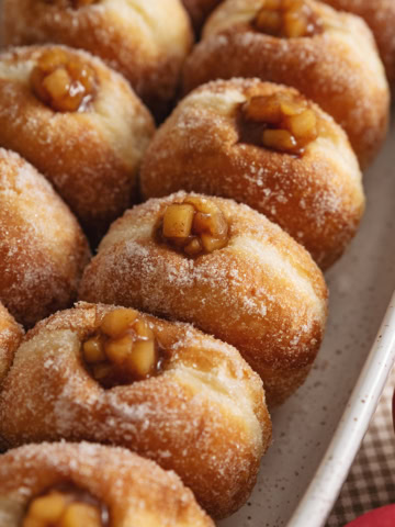 Two rows of apple pie donuts lined up in a baking dish.