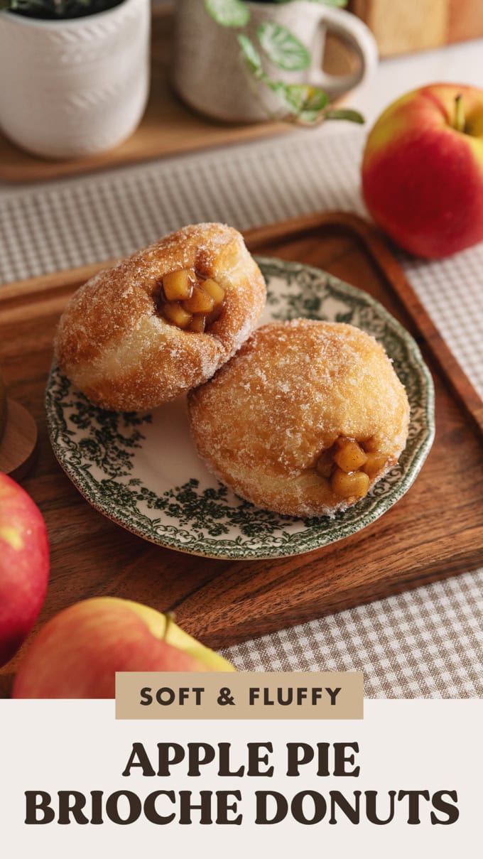 Two apple pie donuts on a plate on a wooden platter.