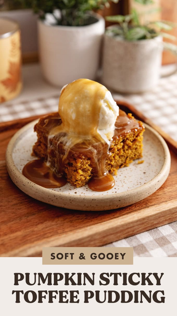 A slice of pumpkin sticky toffee pudding on a plate with a scoop of ice cream on top and toffee sauce dripping down.