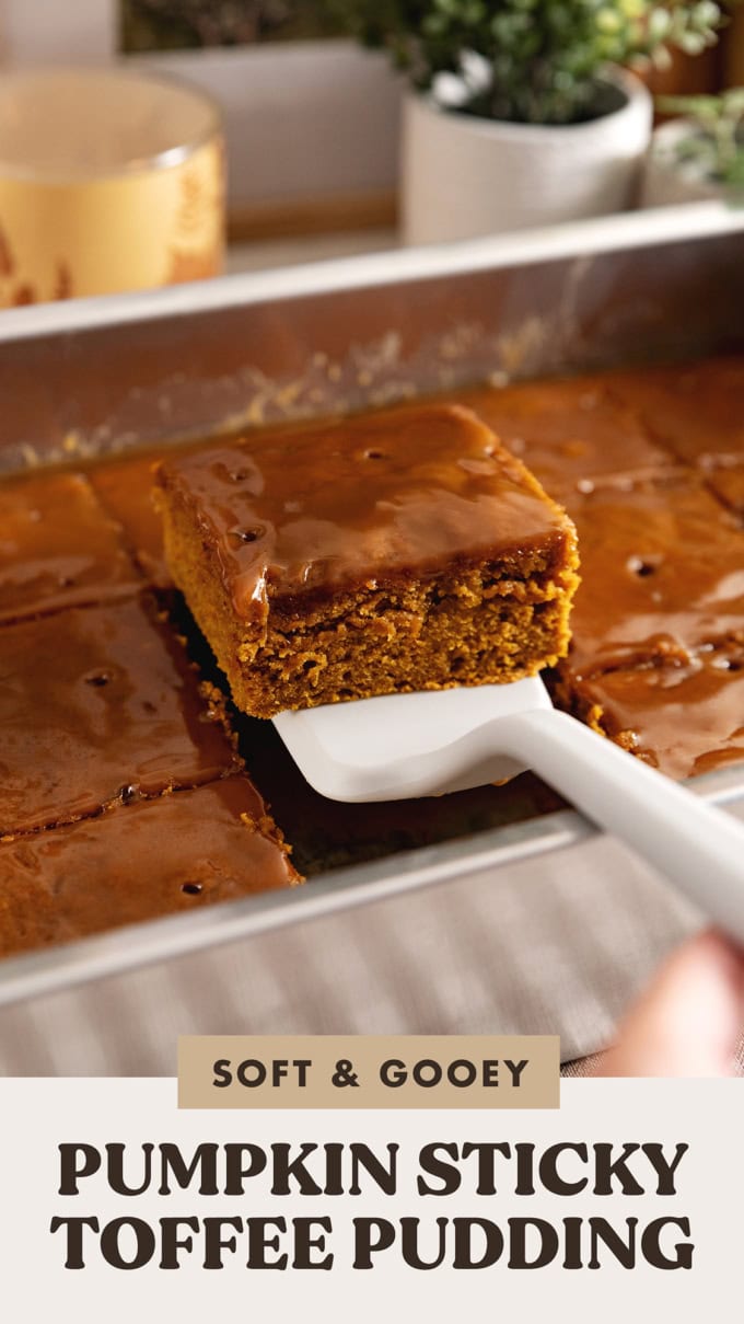 A square of pumpkin sticky toffee pudding being lifted from a baking tray with a spatula.