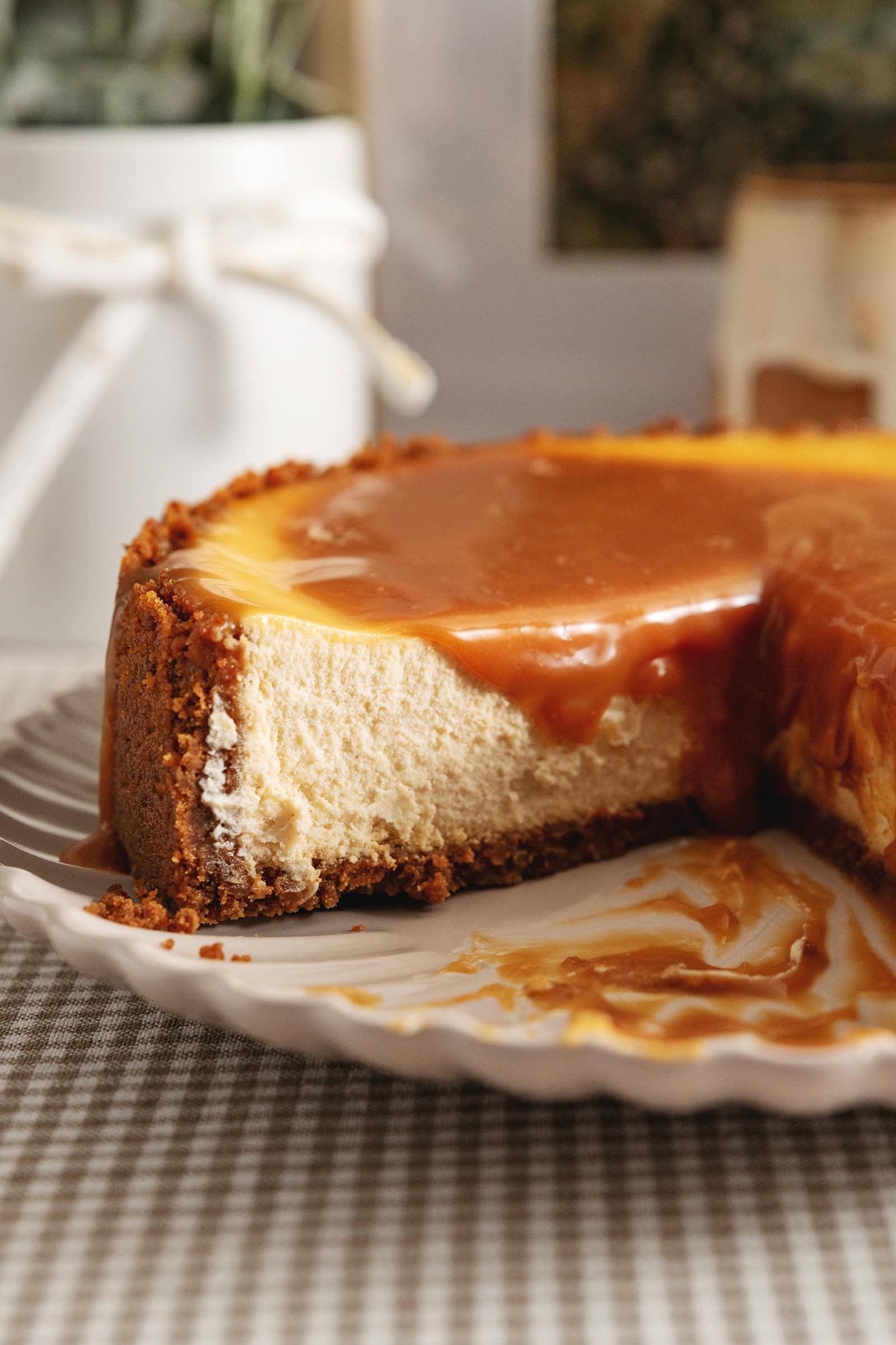 Close-up of the cut edge of a salted caramel cheesecake to show the texture inside with caramel dripping down.