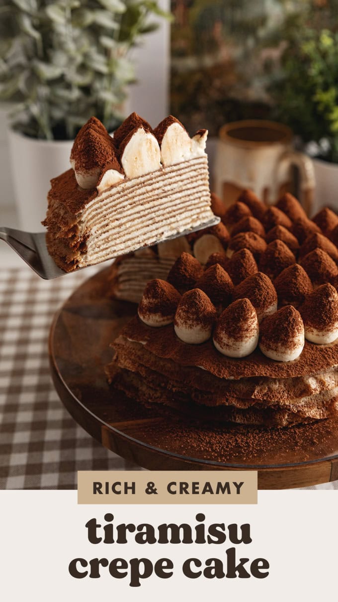 A slice of tiramisu crepe cake being lifted with a cake server from the rest of the cake to show the crepe layers inside.