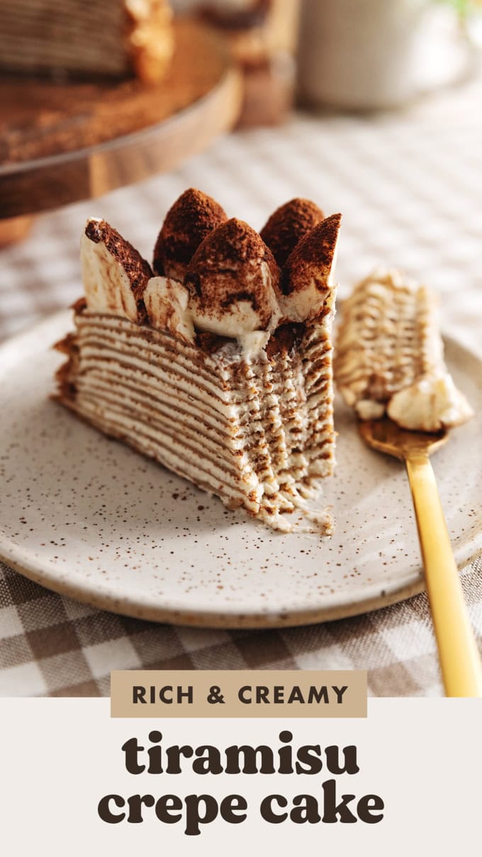 A slice of tiramisu crepe cake on a plate with a forkful taken out of it and the fork laying next to it.