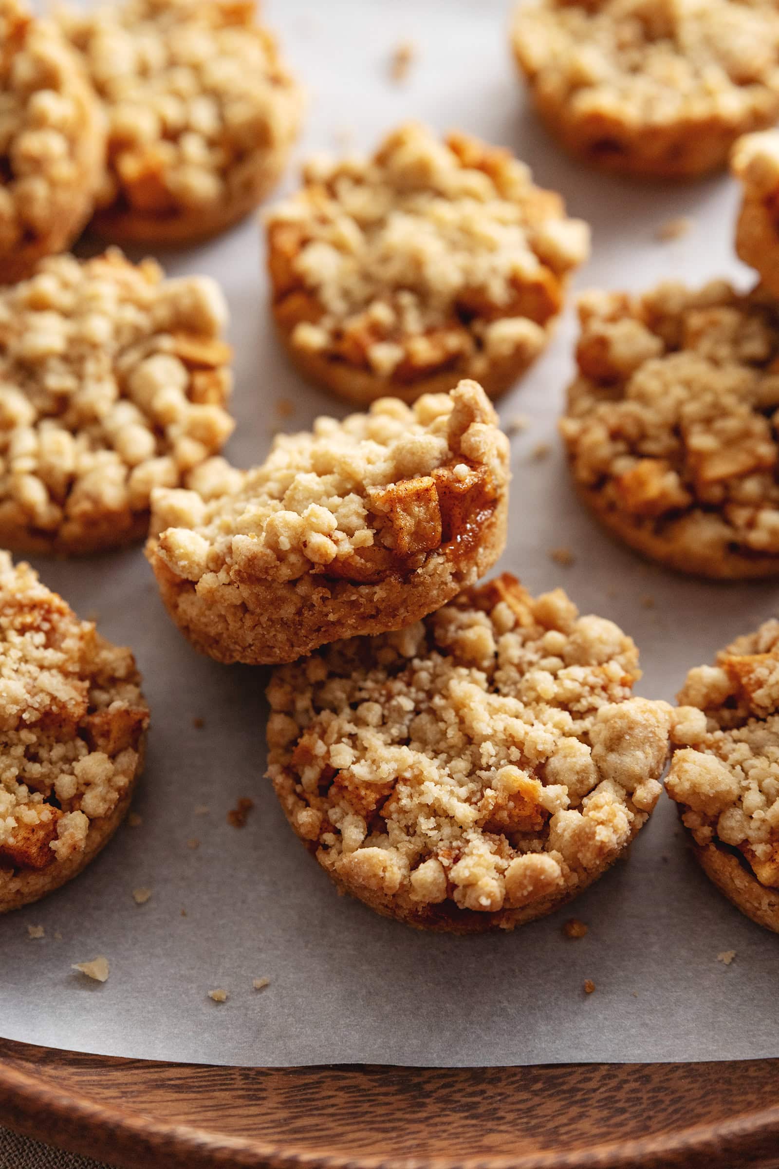An apple crumble cookie resting on another cookie to show the apple filling inside.