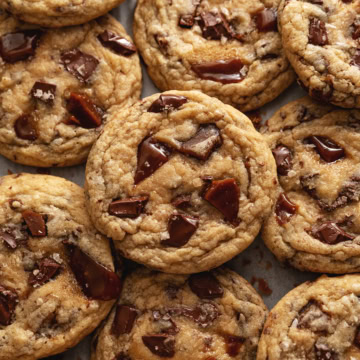 Several toffee cookies slightly overlapping on parchment paper.
