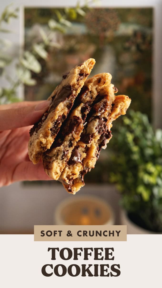 Hand holding four halves of toffee cookies to show the melted chocolate inside.