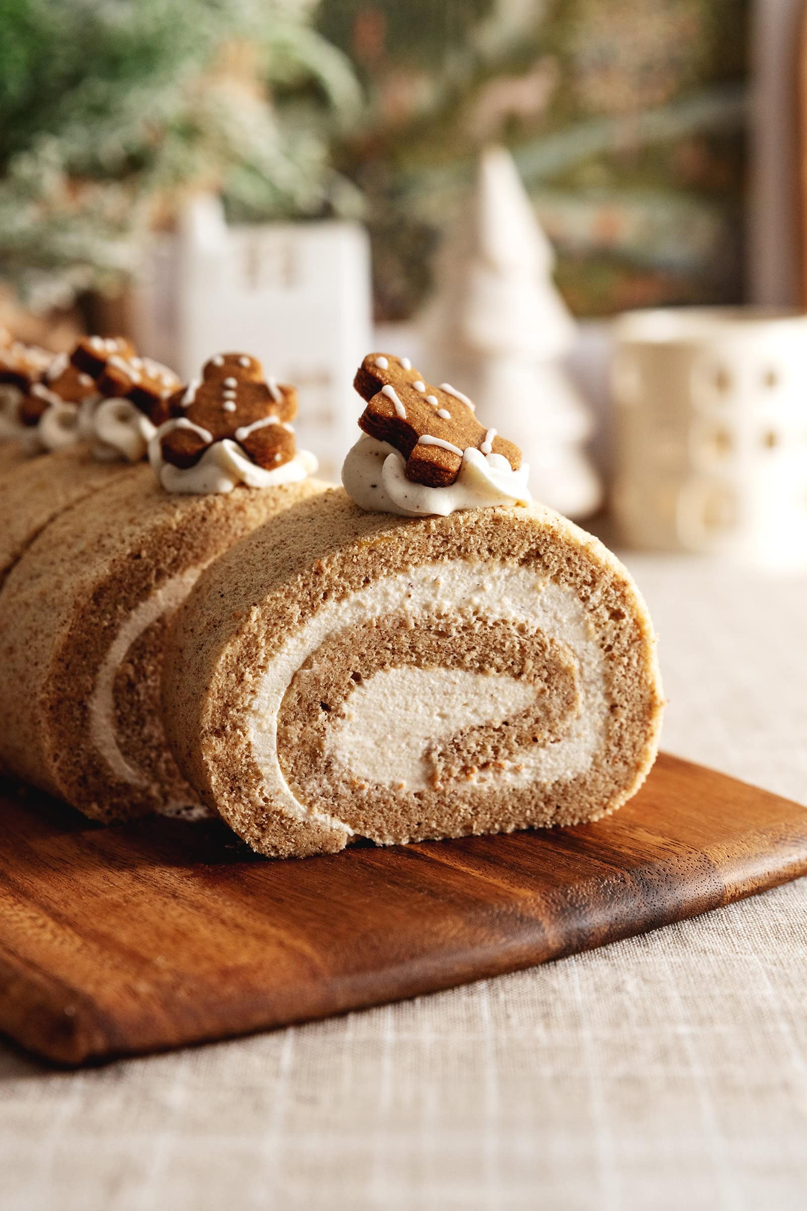 Slices of gingerbread roll cake lined up on a wooden board.