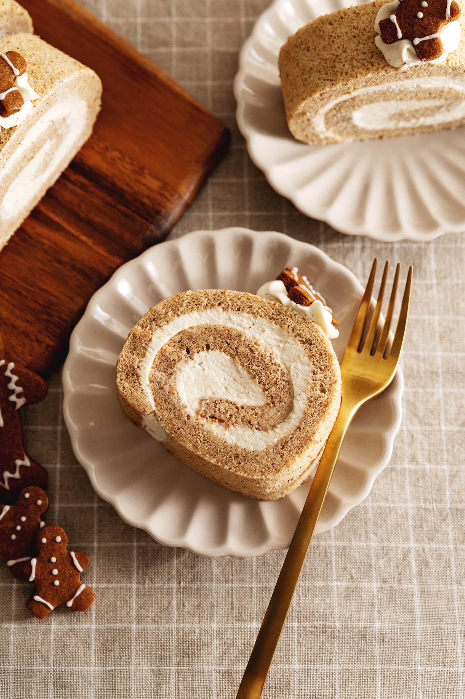 A slice of gingerbread roll cake on a plate with a fork.