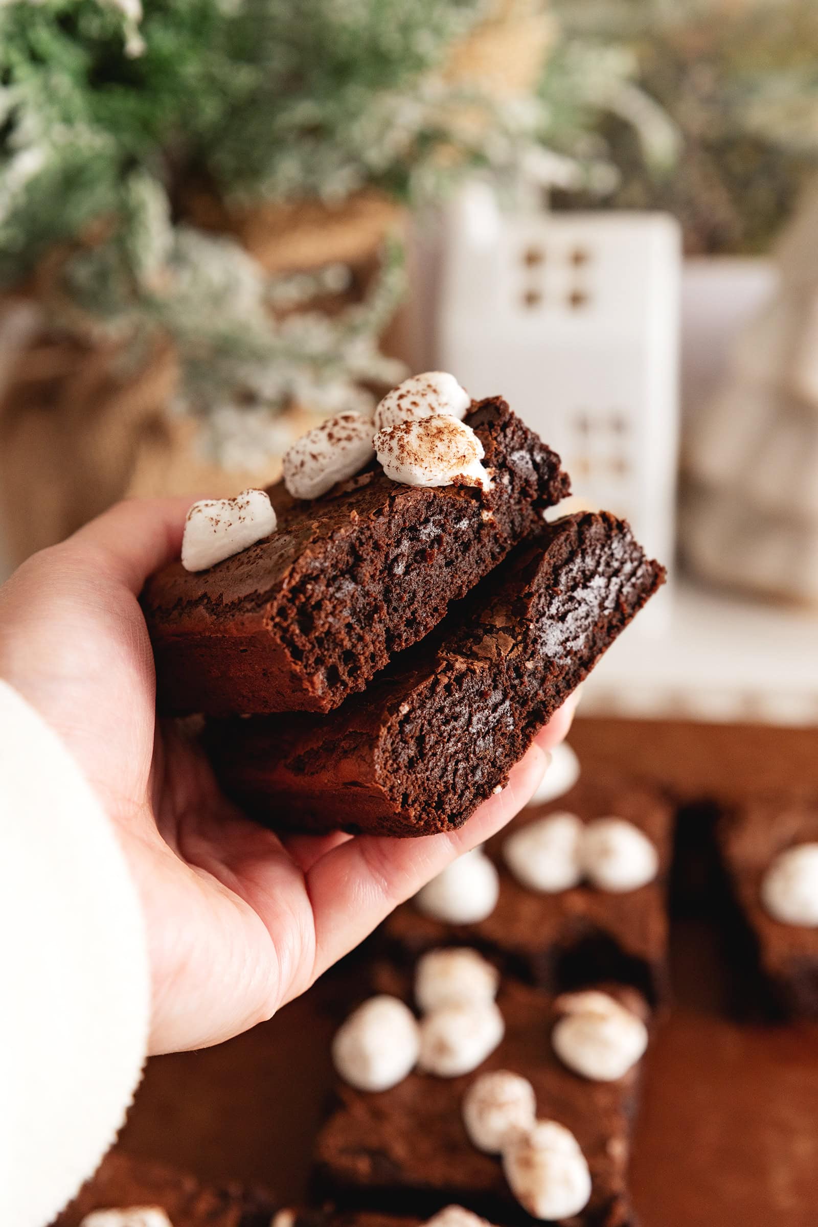 A hand holding two hot chocolate brownies to show the texture inside.