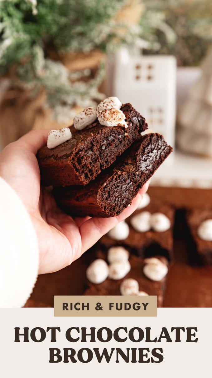 A hand holding two hot chocolate brownies to show the texture inside.