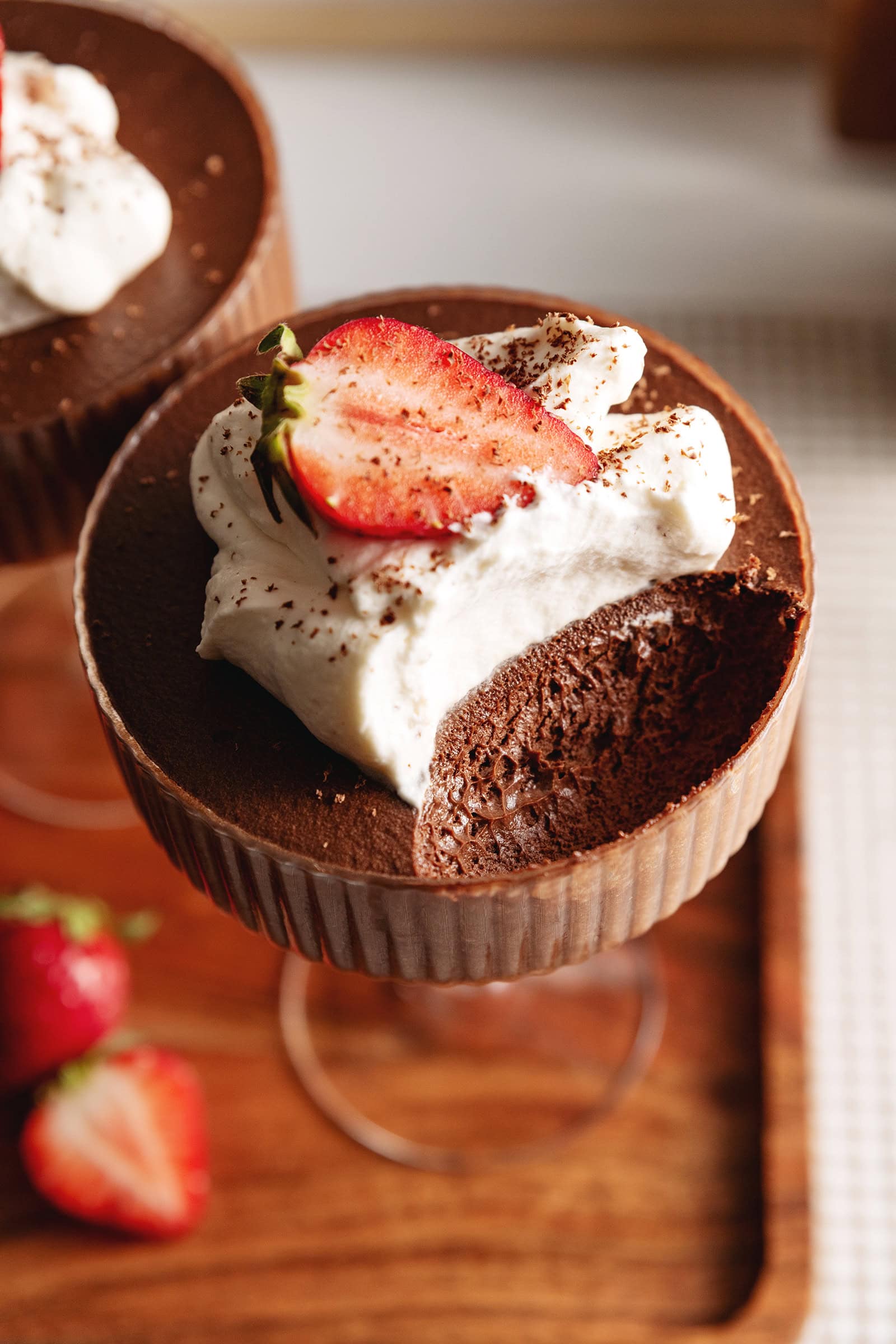 A chocolate mousse cup with a spoonful scooped out of the cup to show the texture inside.